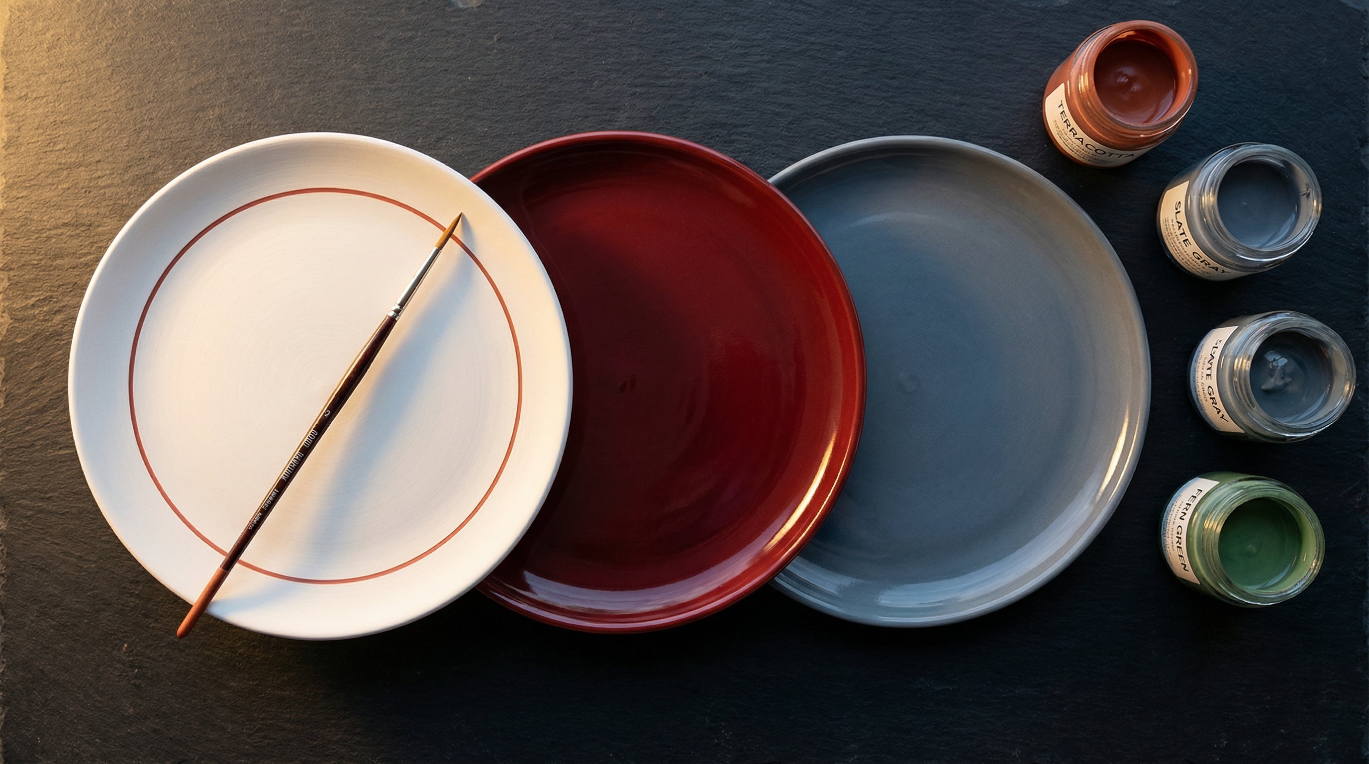Custom ceramic plates with proprietary glaze colors on a production workbench