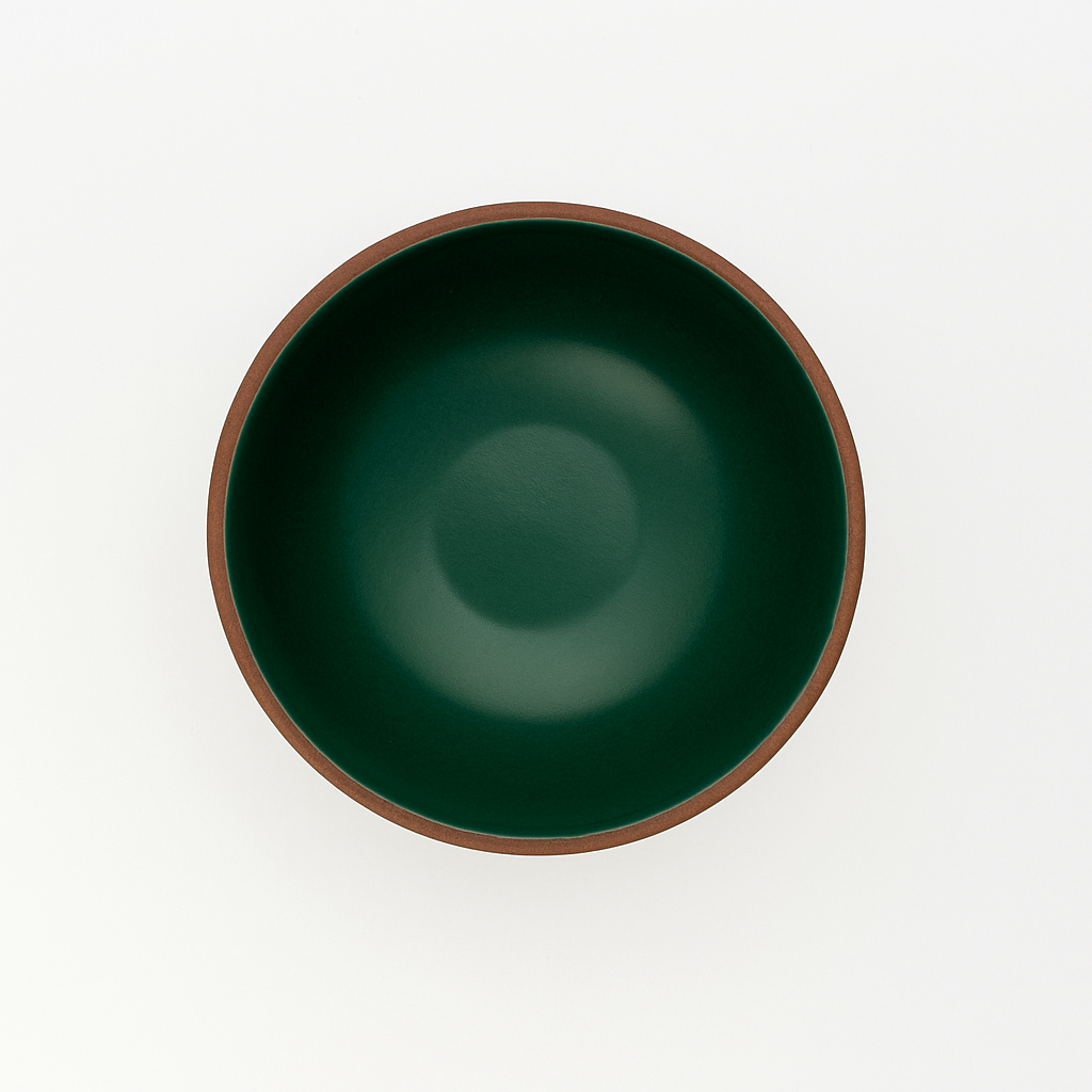 Green ceramic bowl with earth-brown hand painted rim on a white background. Made in USA